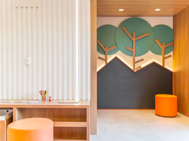 Espaço Bambini com mesa infantil e painel lúdico de árvores