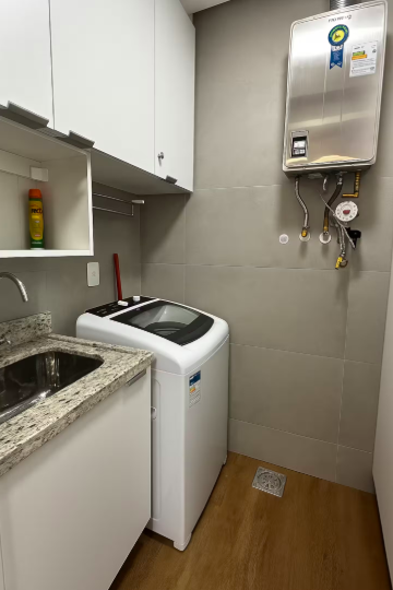 Lavanderia com máquina de lavar, tanque e aquecedor a gás
