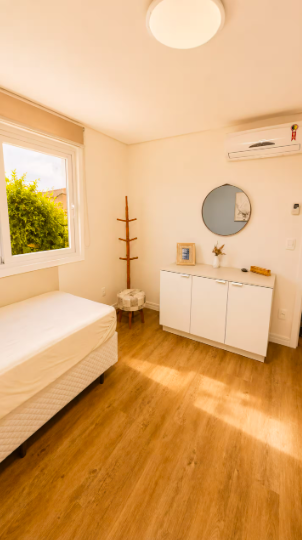 Quarto claro com janela ampla e ar-condicionado