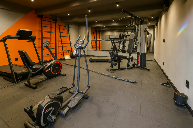 Academia equipada com esteira, elíptico e estação de musculação