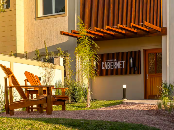 Entrada da Torre Cabernet com cadeiras de madeira no jardim